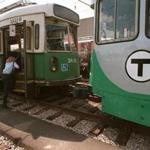 Newton, MA--5/29/96--GREEN LINE PAINT JOB--So far 11 of the 95 Green Line MBTA cars have been painted with the new colors - Atlanta Green and Platinum Mist (right). A T worker climbs aboard a yet-to-be painted car in the yard of the Riverside station.